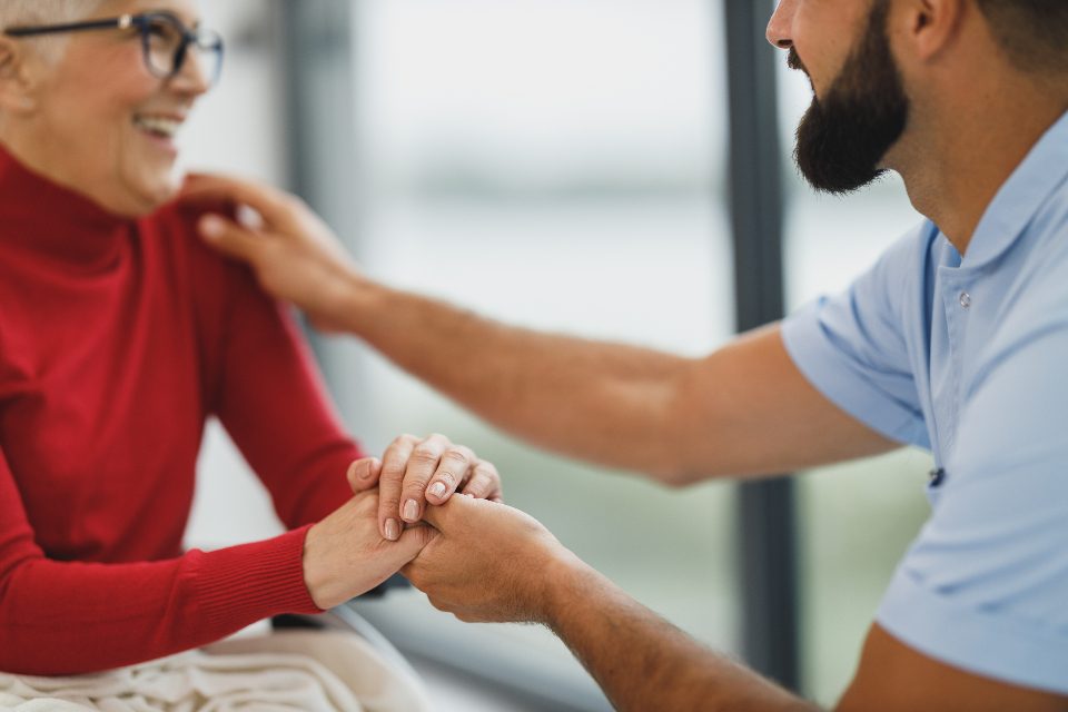 A caregiver gently comforting a senior woman at home